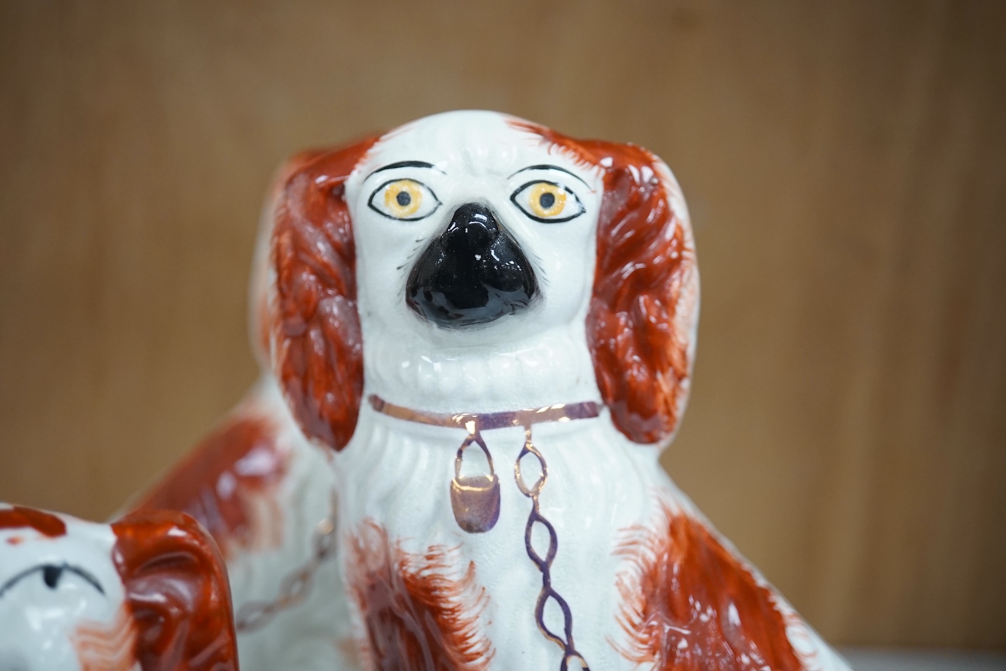 A pair of Staffordshire potter spaniels, and a similar smaller example, taller 18cm. Condition - smaller and one larger heavily restored